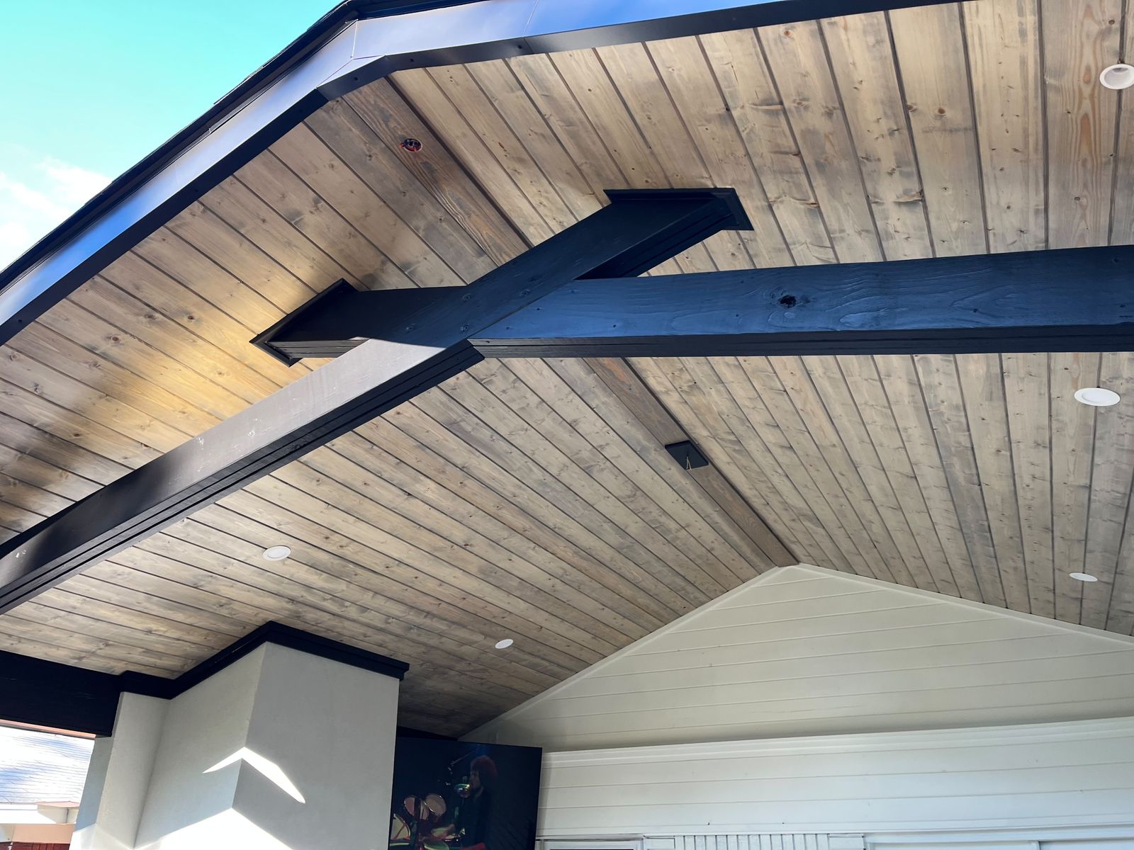 Black beams under a cedar ceiling